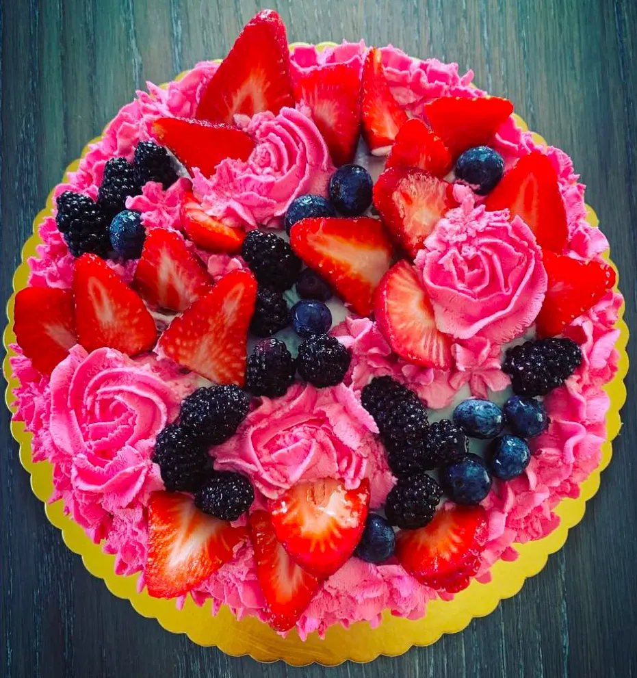 Torta Chantilly con decoro di rose fragole e mirtilli